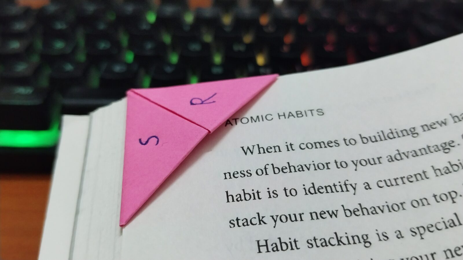 A pink paper bookmark folded over the top corner of a page